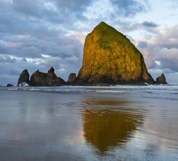 Majestic Haystack Rock at Cannon Beach, Oregon, with waves crashing.